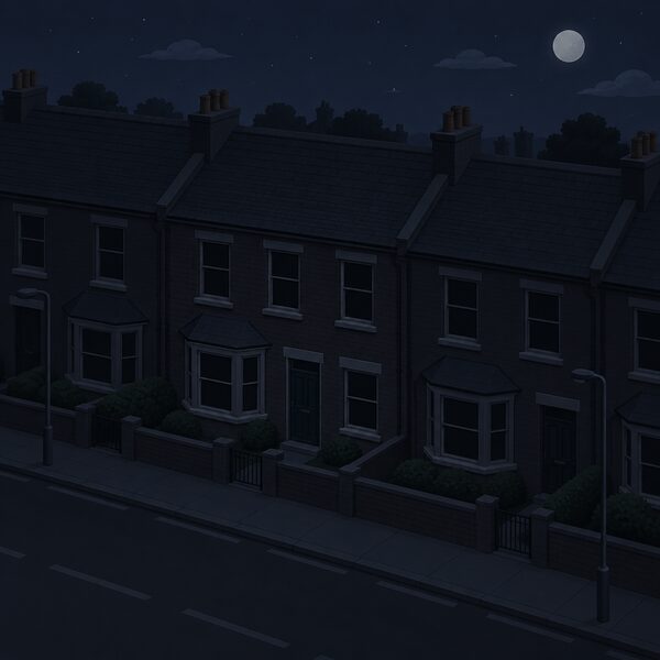 A dark terraced house at night during a power cut, its windows black while neighbouring houses and the street outside, including unlit street lamps, are also in darkness under a night sky.