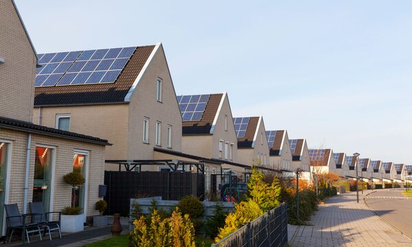 A row of new suburban houses with solar panels installed on their roofs
