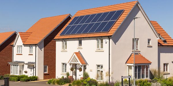 A modern UK estate house with solar panels on its tiled roof