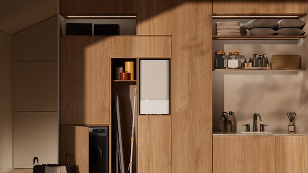 A white wall-mounted boiler installed in a recess of a wooden utility room cupboard next to a washing machine and sink