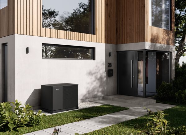 A Stiebel Eltron air source heat pump unit installed outside a modern house beside the front door