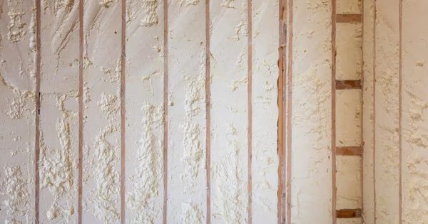 Spray foam insulation applied between wooden wall studs in a building under construction
