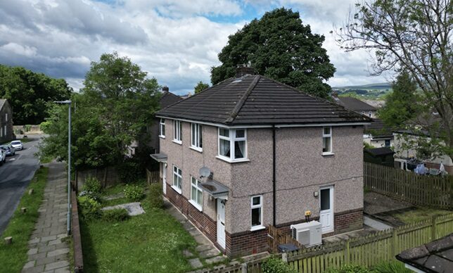 A UK semi-detached house with a heat pump unit installed at the rear