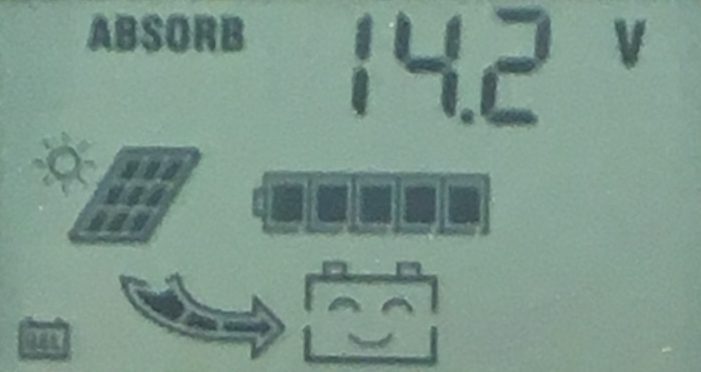 Close-up of a solar charge controller LCD display showing 14.2V absorb charge with solar panel and battery icons