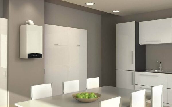 A white wall-mounted condensing gas boiler installed in a modern kitchen-dining room