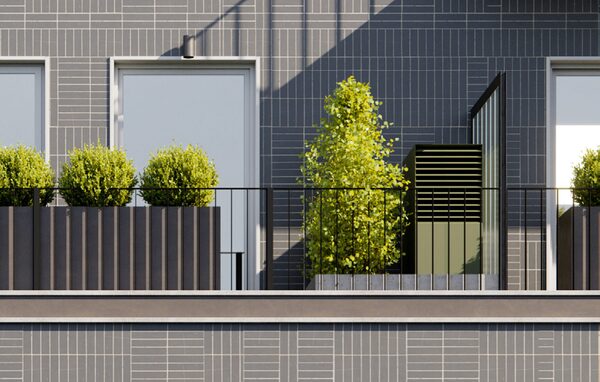 A heat pump outdoor unit installed on an apartment balcony beside planters and grey tiled walls