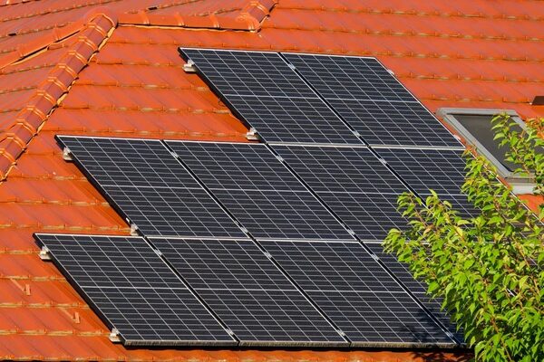 Solar panels mounted on a red-tiled house roof