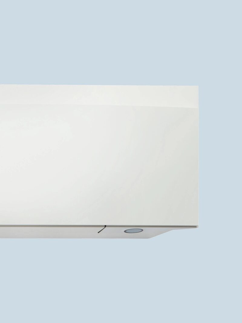 A close-up corner of a white wall-mounted air conditioning indoor unit against a pale blue background