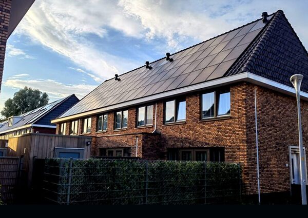A brick house with a large roof of in-roof solar panels