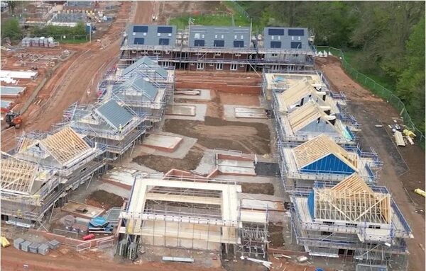 Aerial view of a housing development under construction with some roofs fitted with solar panels