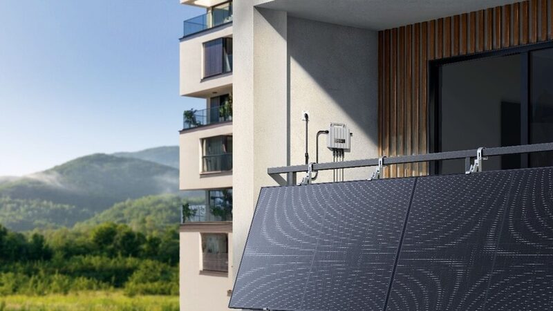 Balcony-mounted solar panels with a wall-mounted microinverter on an apartment building