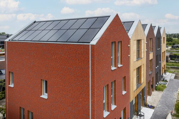 A row of new brick houses with solar panels mounted in-roof on the sloping roofs
