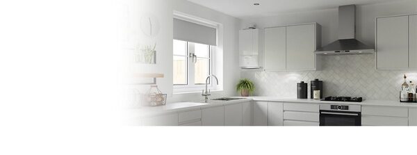 A wall-mounted boiler installed in a modern white kitchen with grey cabinets and an oven