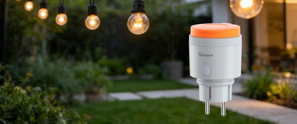A Sonoff S61s outdoor smart plug with orange top shown against a garden background with hanging festoon bulbs