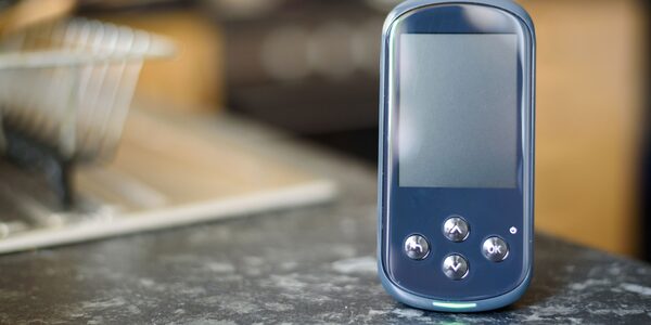 A smart meter in-home display with a blank screen standing on a kitchen worktop