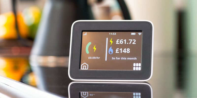 A smart energy monitor display on a kitchen worktop showing electricity and gas costs so far this month