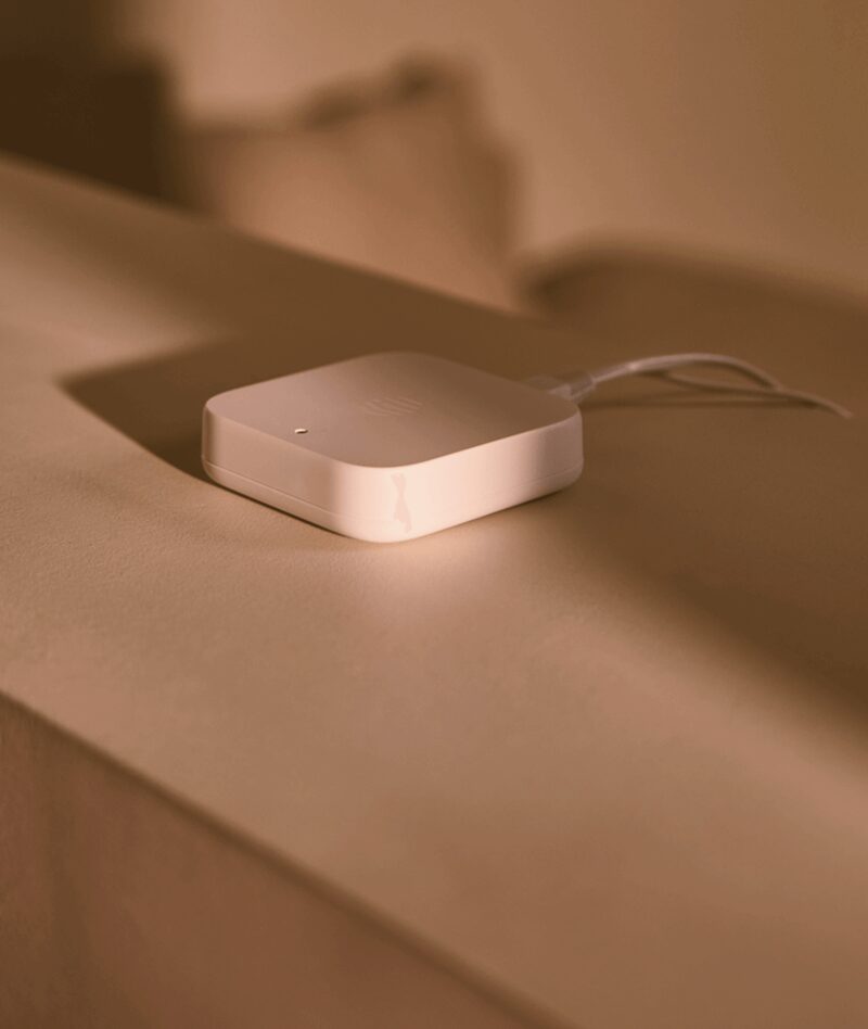 A white Hive smart home hub plugged in on a shelf