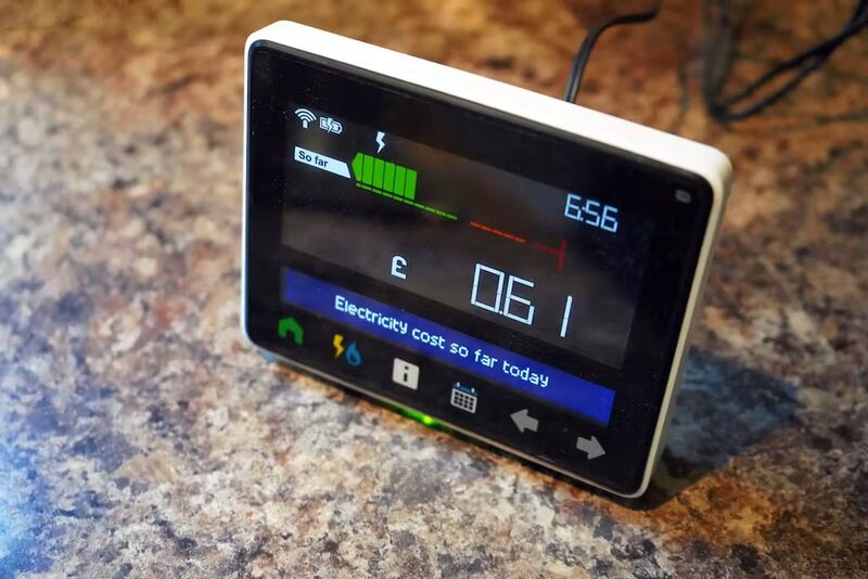 A smart meter in-home display showing electricity cost so far today, sitting on a granite kitchen worktop