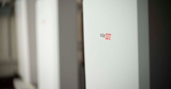A white SolarEdge home battery unit mounted indoors, with the SolarEdge logo visible on its front panel