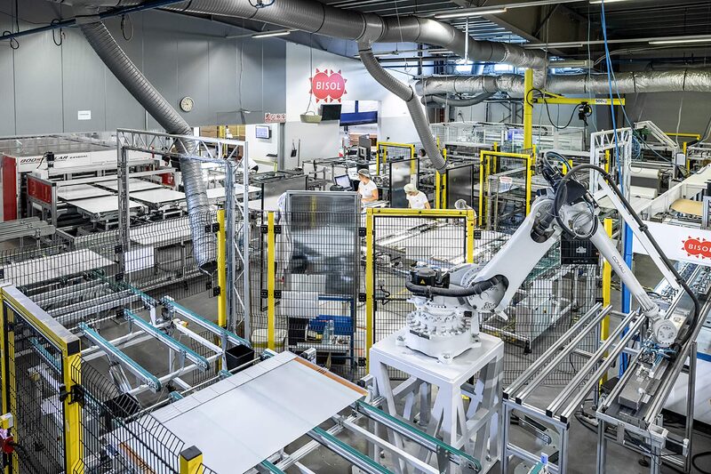A robotic arm and automated production line manufacturing solar panels inside the BISOL factory