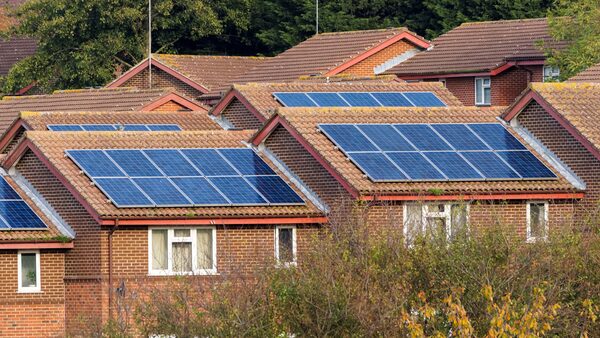 Rows of brick houses with solar panels installed on their tiled roofs