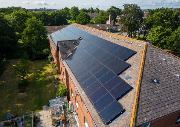 Aerial view of solar panels installed on the roof of a brick block of flats
