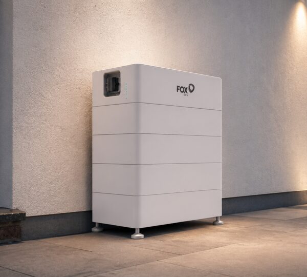 A white Fox ESS home battery unit installed on the floor against an exterior wall