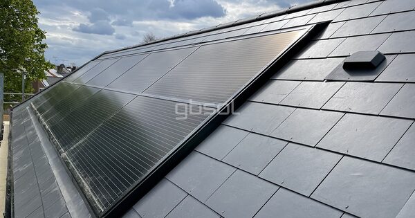 In-roof solar panels integrated flush into a slate-tiled roof on a house