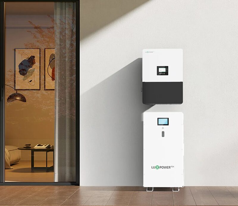 A LuxpowerTek wall-mounted hybrid inverter and floor-standing home battery unit installed on a white wall next to a doorway