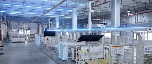 A solar panel manufacturing factory floor with automated production lines and a solar module on the line