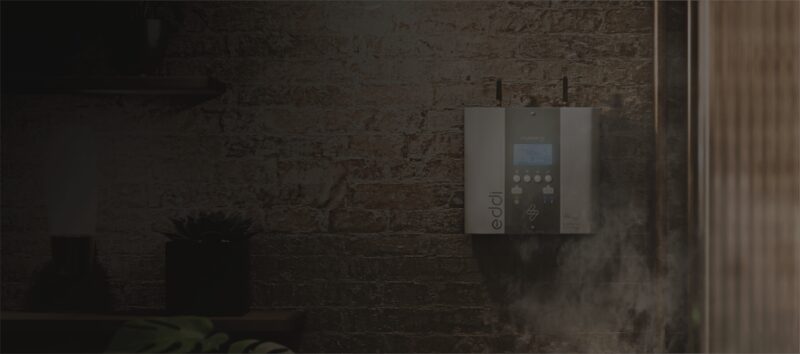 A myenergi eddi solar water heating controller mounted on a brick wall