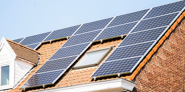 Solar panels installed on the tiled roof of a brick house