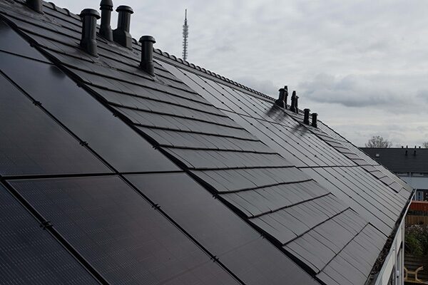 In-roof solar panels integrated flush into a tiled house roof with vent pipes