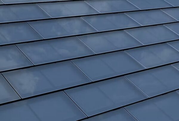 A close-up of a roof covered in blue-grey solar tiles