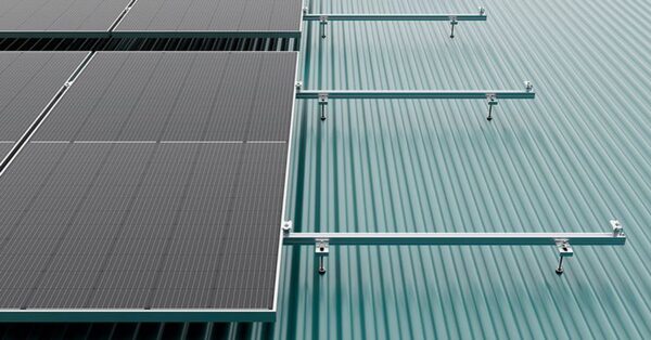 Solar panels mounted on a corrugated metal roof with aluminium mounting rails and clamps