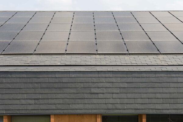 In-roof mounted solar panels integrated flush into a slate-tiled roof of a building