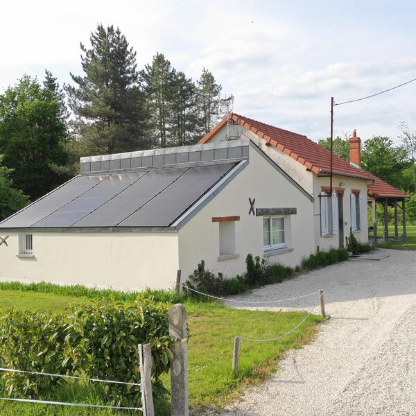 A rural house with solar panels integrated into the roof of an extension