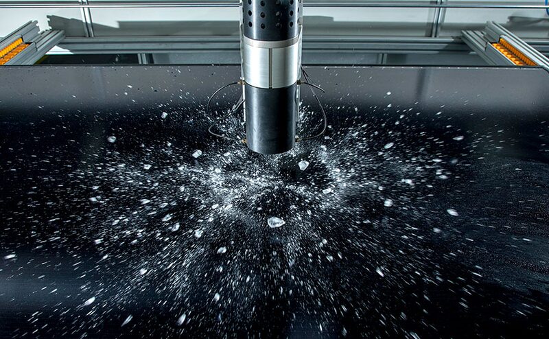 A hail impact test machine striking a solar panel with ice balls during quality testing