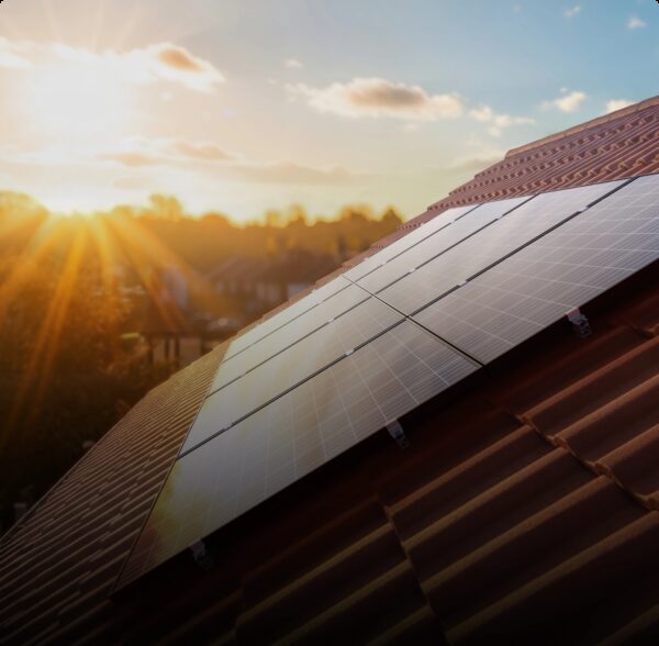 Solar panels installed on a tiled house roof at sunset