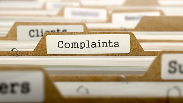 A close-up of filing folders with a tab labelled 'Complaints' among other labelled folders