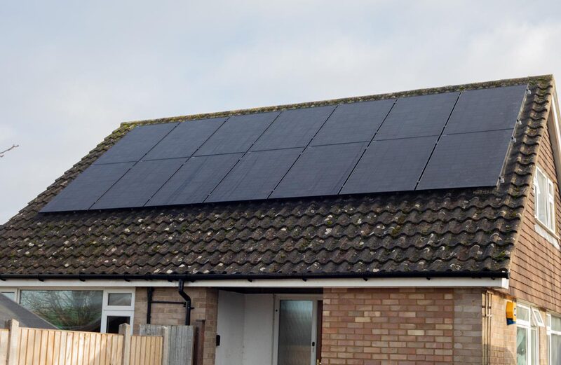 A brick house with solar panels fitted across its tiled roof