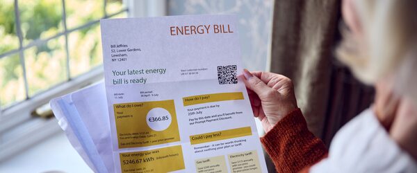 A woman holding a mock energy bill letter showing a £366.85 payment due