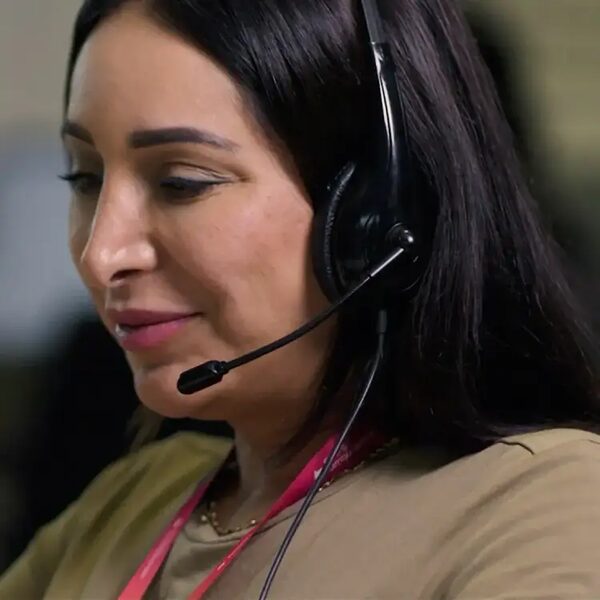 A woman wearing a headset with microphone, working in a call centre