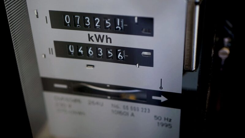 A close-up of an old mechanical electricity meter with two kWh dial counters