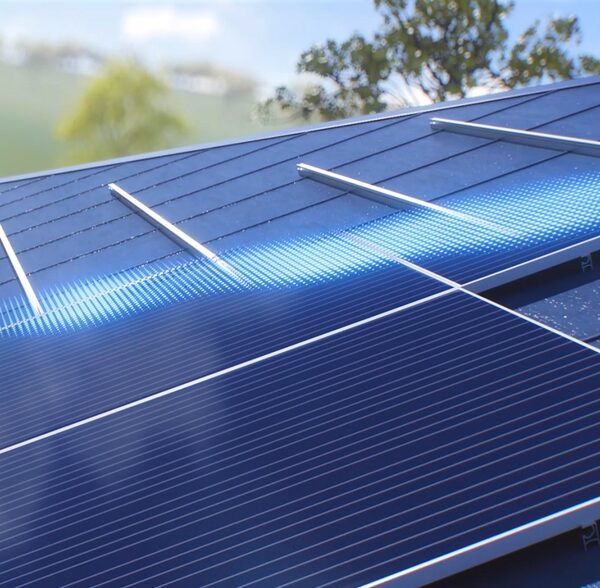 A close-up of solar panels mounted on a roof with sunlight reflecting off the cells