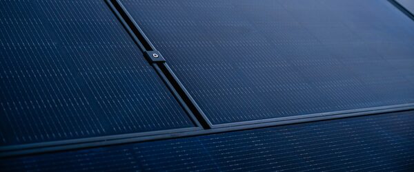 A close-up of dark blue solar panels fitted on a roof