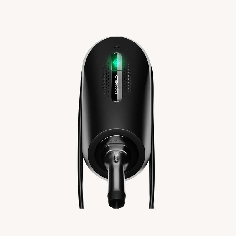 A black OVO Charge smart EV home charger with a green light and tethered cable, shown against a plain background