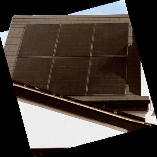 Six dark solar panels mounted on the tiled roof of a house