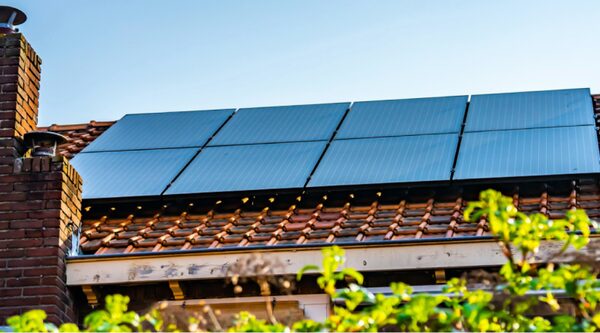 Solar panels installed on a tiled roof of a brick house