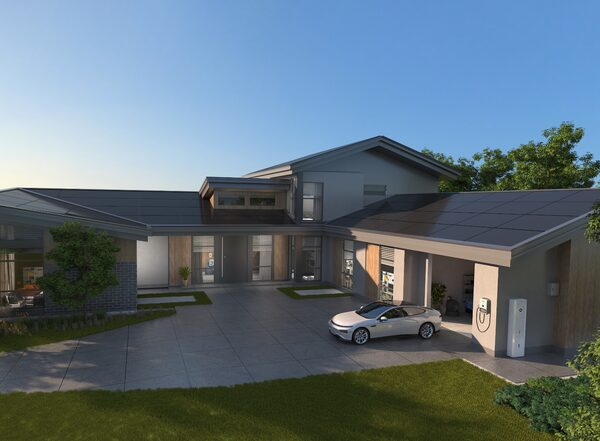 A modern house with solar panels on the roof, an electric car charging in the driveway and a wall-mounted charger